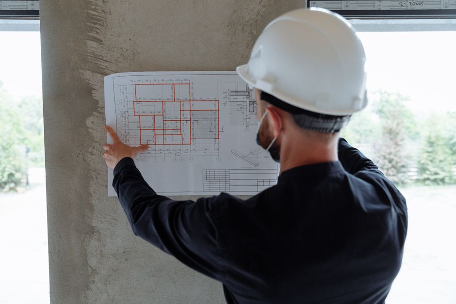 Contractor in a hard hat reviewing project plans on a job site