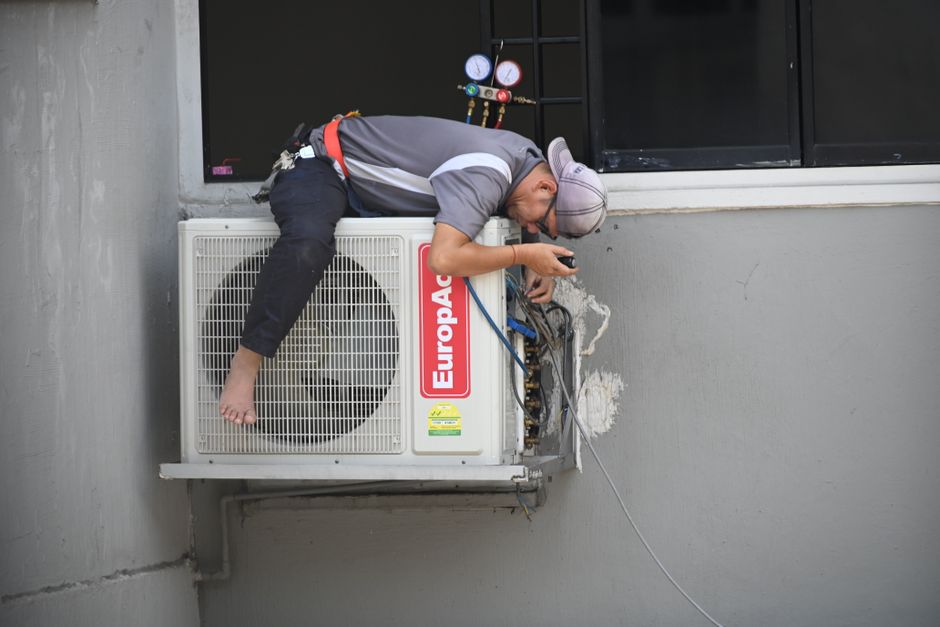 Technician repairing an outdoor air conditioning unit